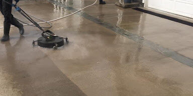 Poseidon Power Washers clean the driveway of a home.